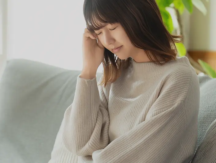 体の不調に悩んでいる女性の画像